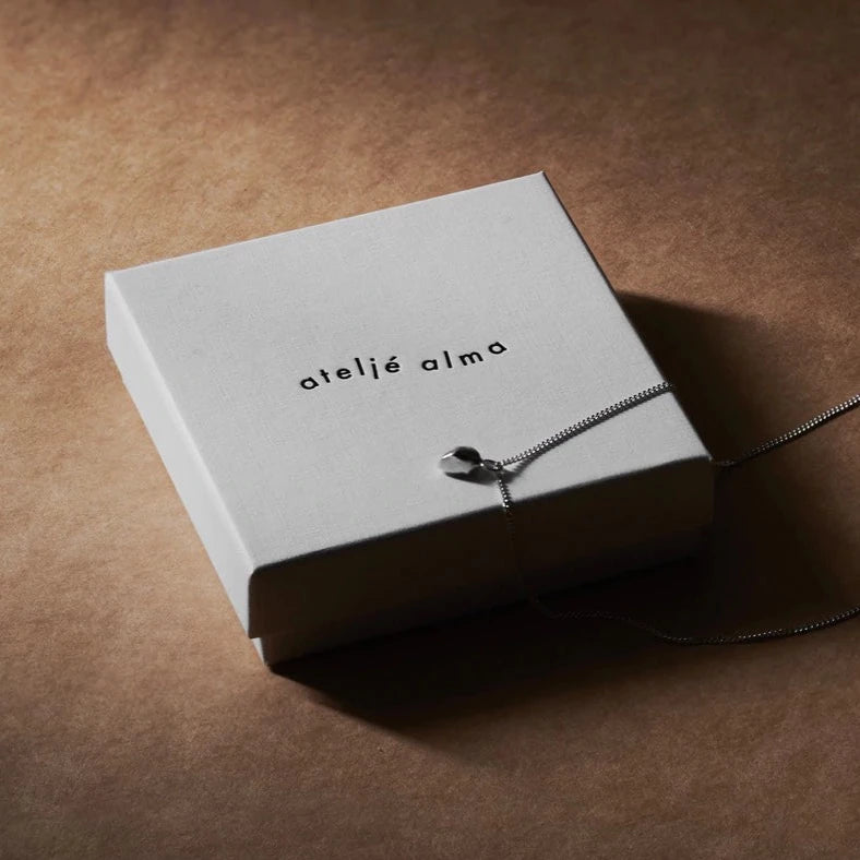 Silver lucky stone necklace on Ateljé Alma gift box